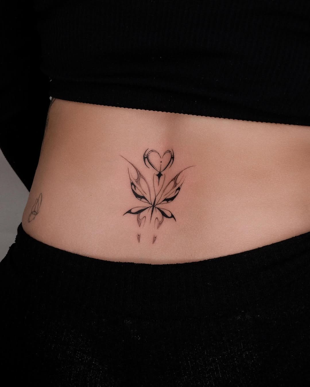 This stunning lower back tattoo features a delicate floral heart design, beautifully blending nature and love.