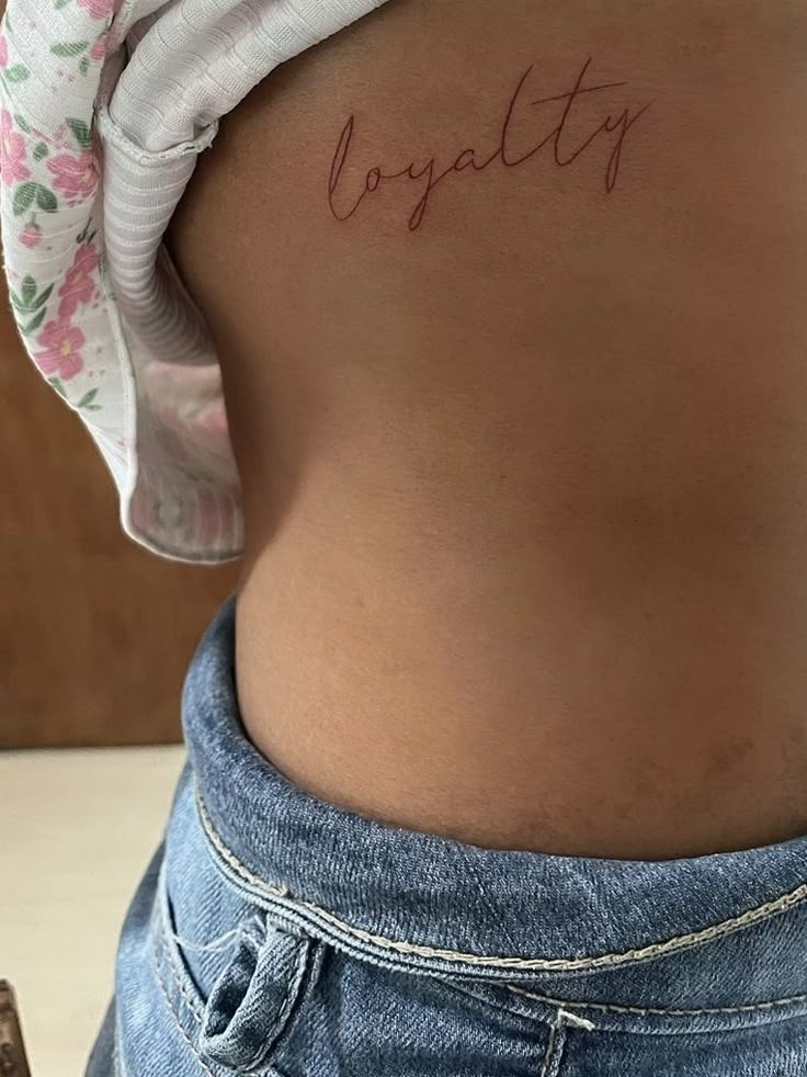 Bold Loyalty Script on Chest Tattoo Design