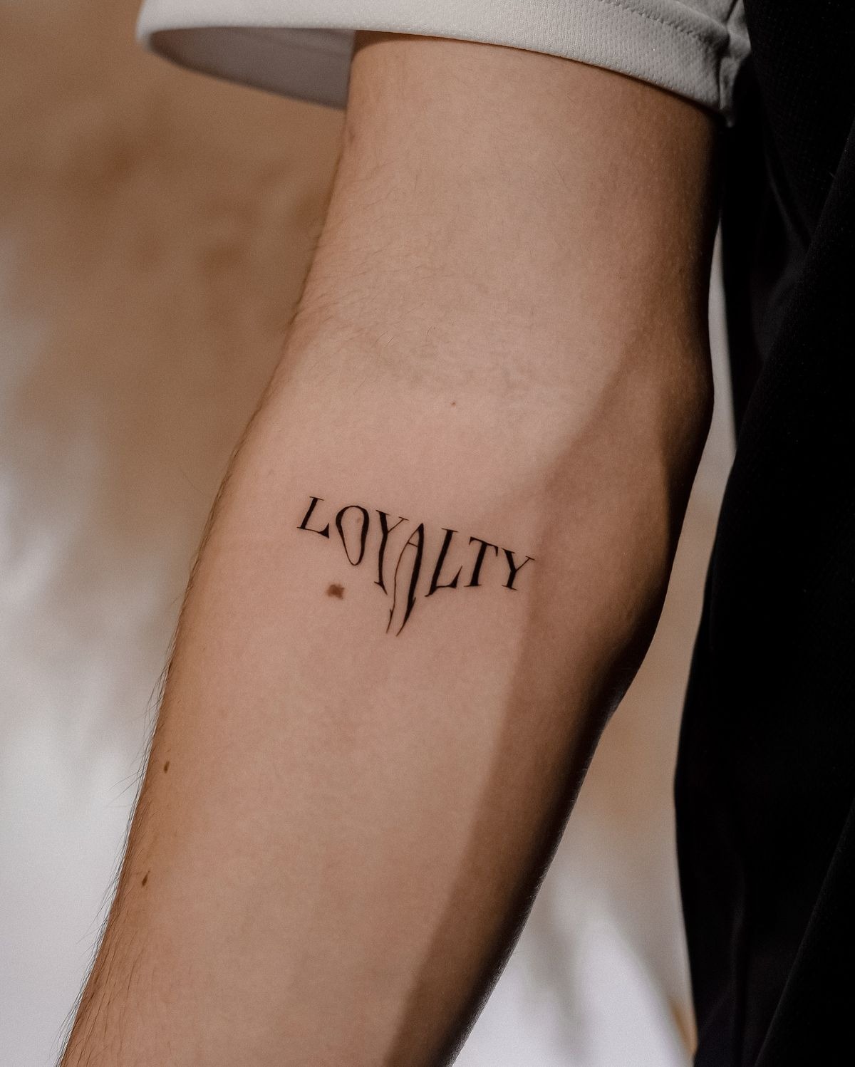 Vertical Loyalty Tattoo on Forearm Tattoo Design