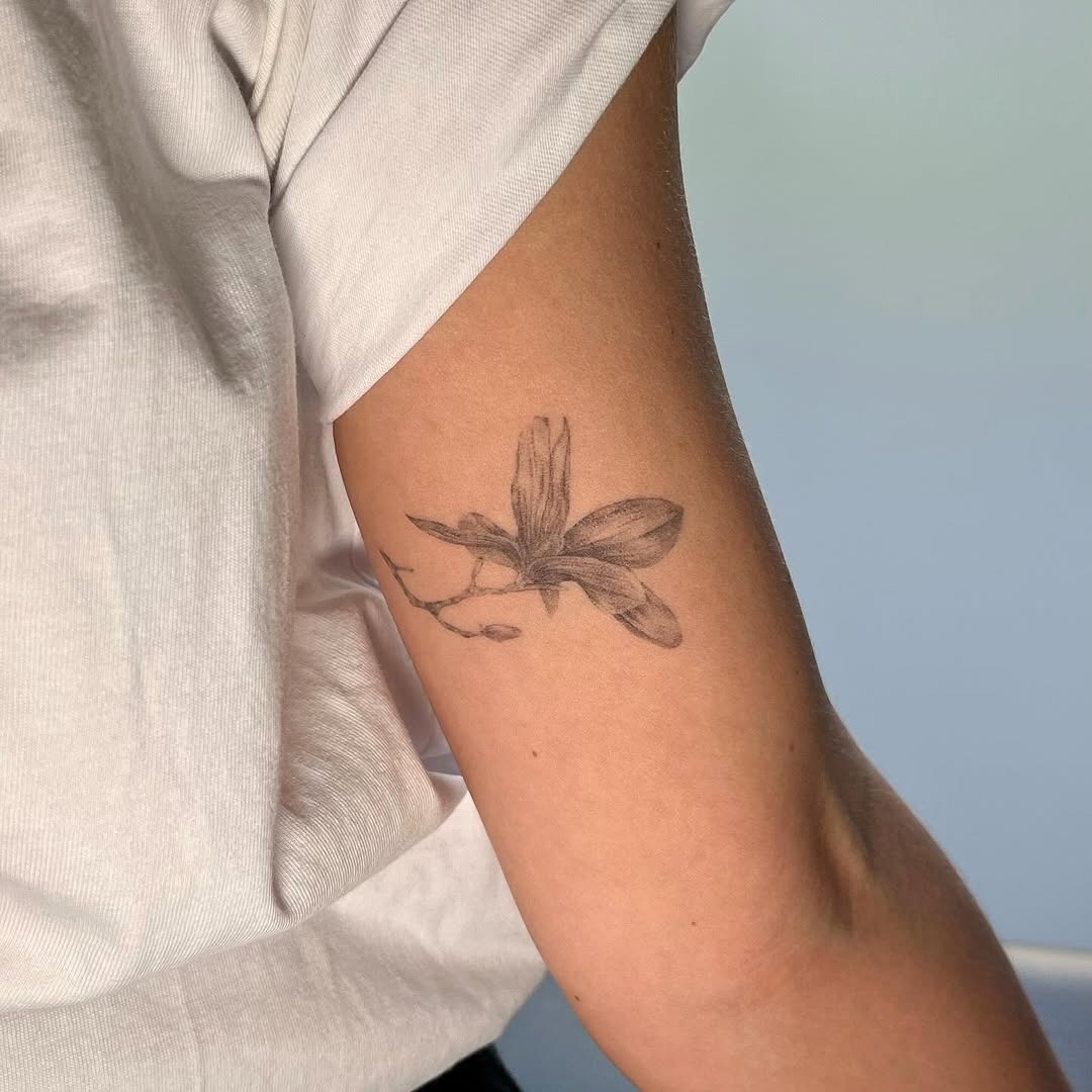 Elegant magnolia tattoo on a relaxed arm. Tattoo Design
