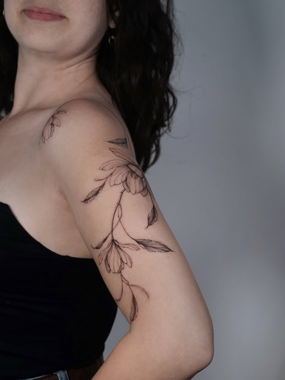 Elegant magnolia tattoo on feminine arm. Tattoo Design