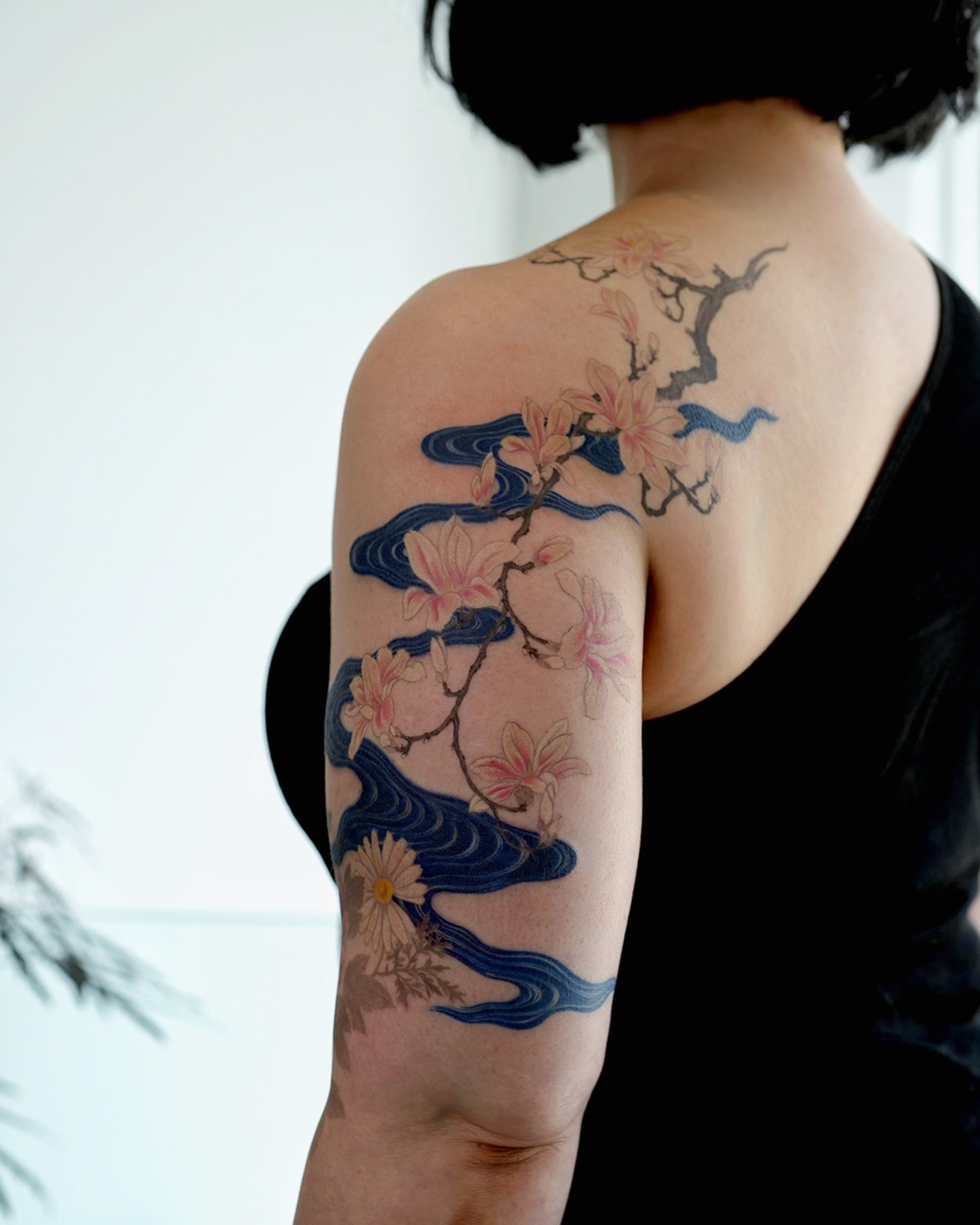 Elegant magnolia tattoo with flowing waves Tattoo Design