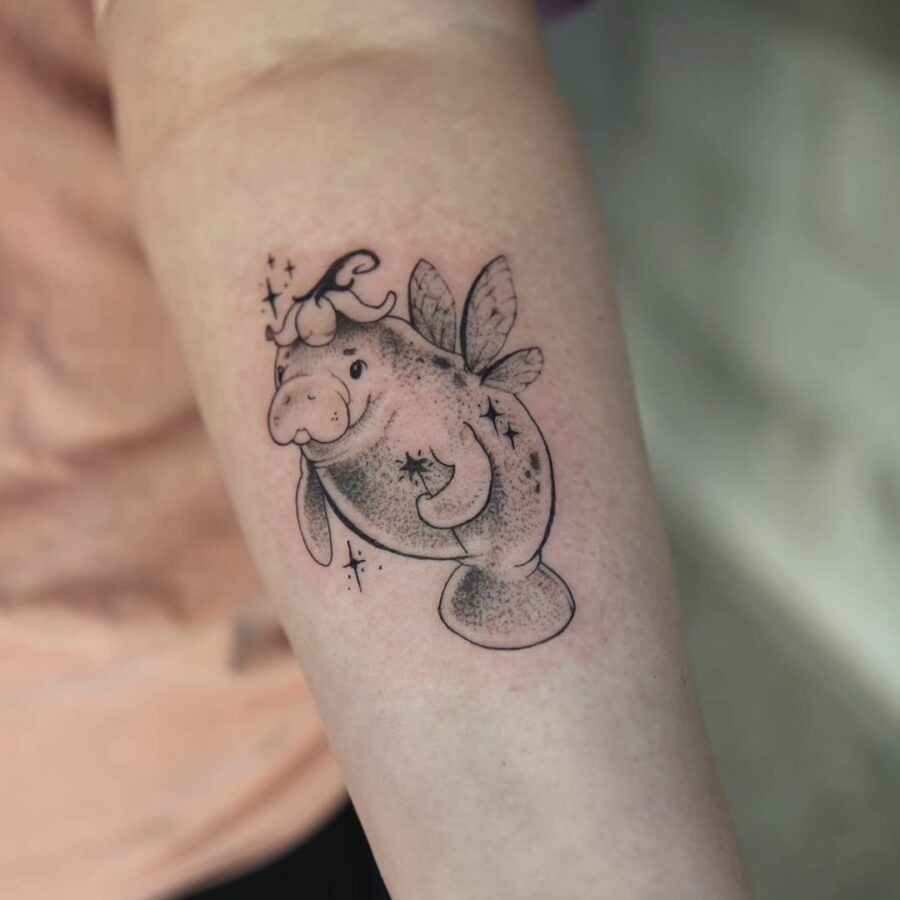 This adorable tattoo features a whimsical manatee adorned with fairy wings and a playful crown.
