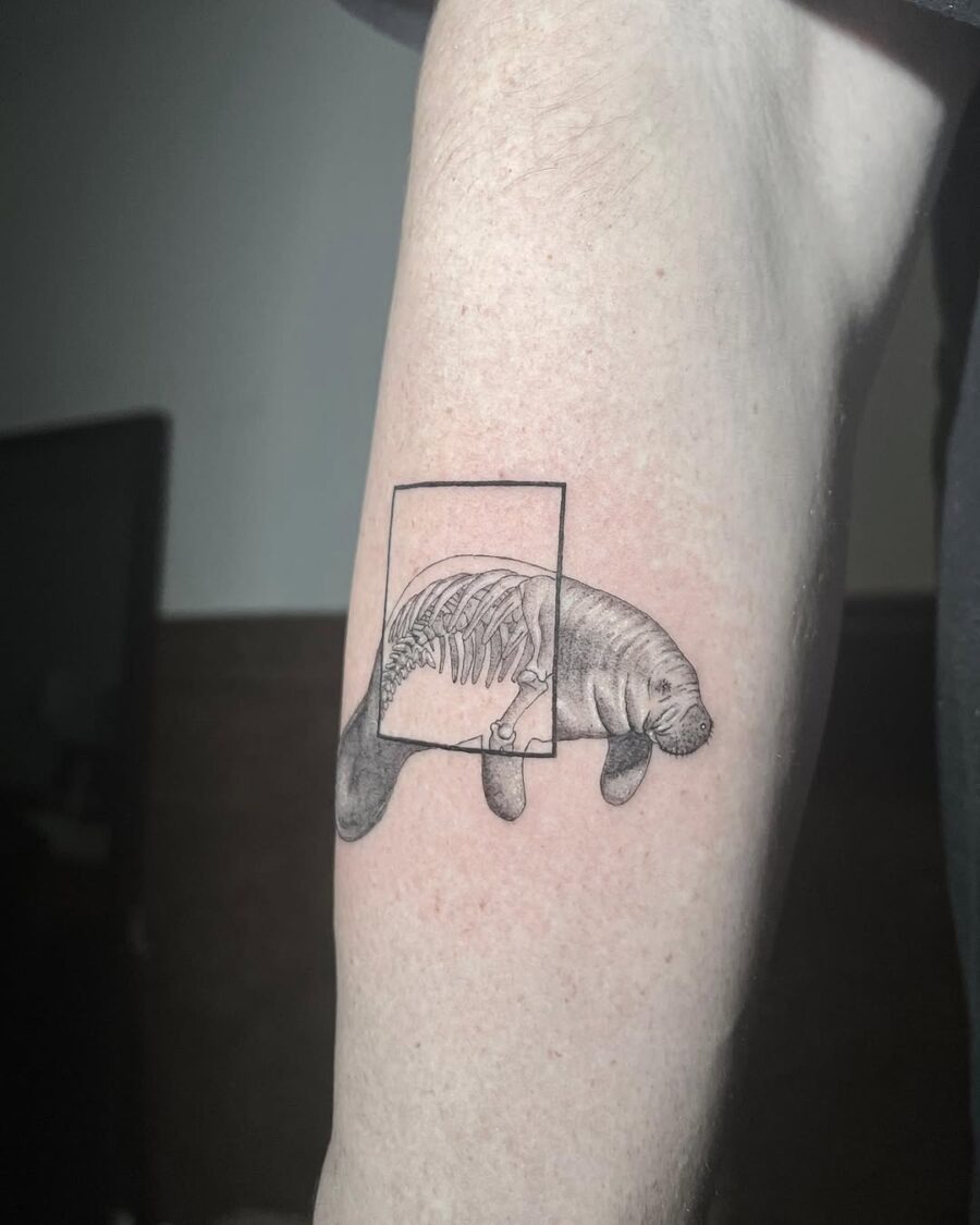 This tattoo showcases a beautifully detailed manatee with a unique twist.