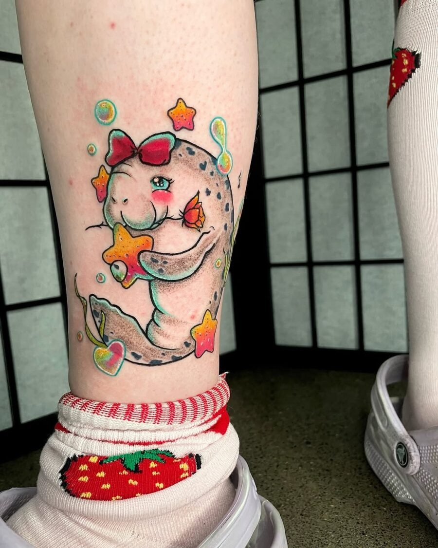 This adorable manatee tattoo features a whimsical design, showing a cute manatee surrounded by colorful stars and bubbles.