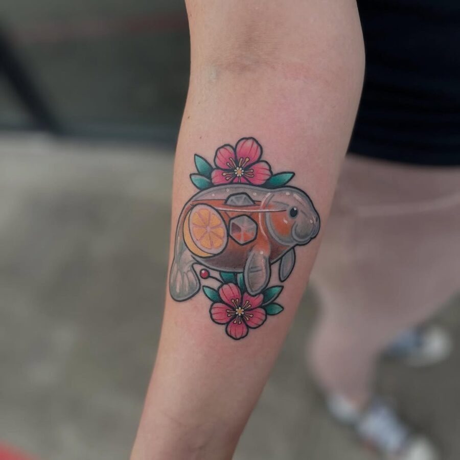 This playful manatee tattoo features a charming character holding a slice of fruit, surrounded by whimsical stars and colorful hearts.