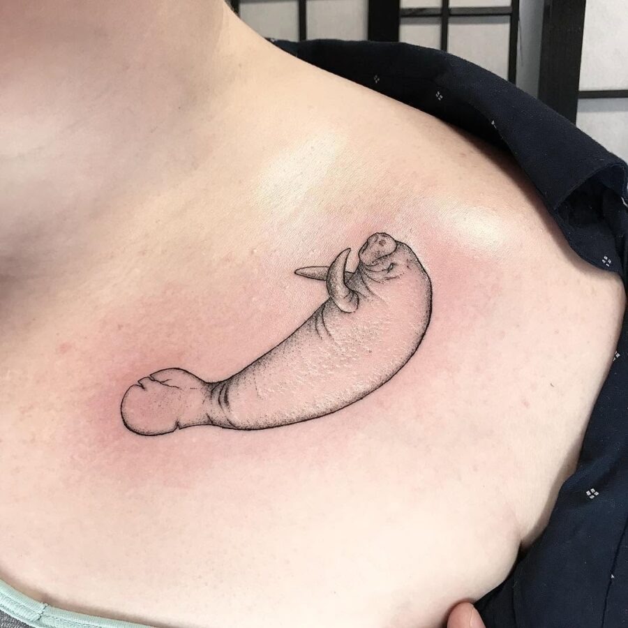This charming manatee tattoo features a soft, flowing design that wraps around the shoulder.
