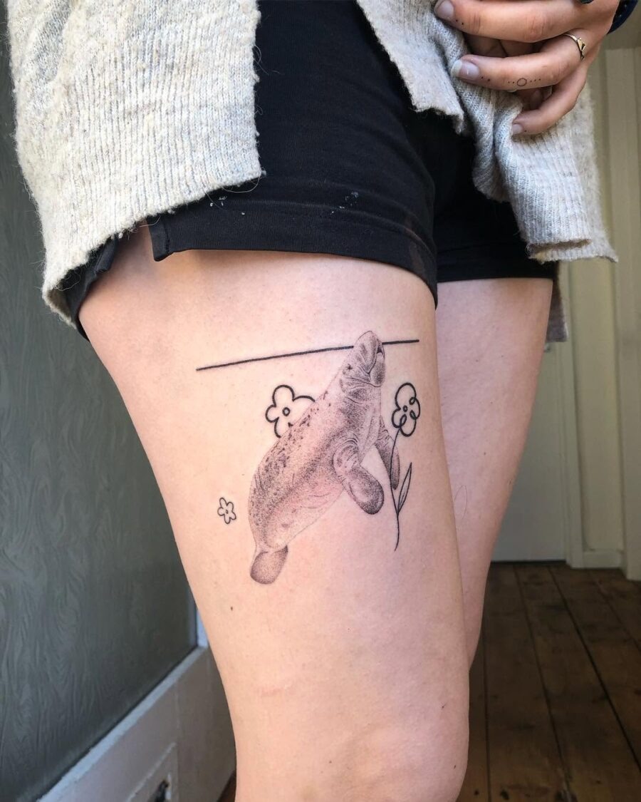 This tattoo features a playful manatee swimming gracefully.