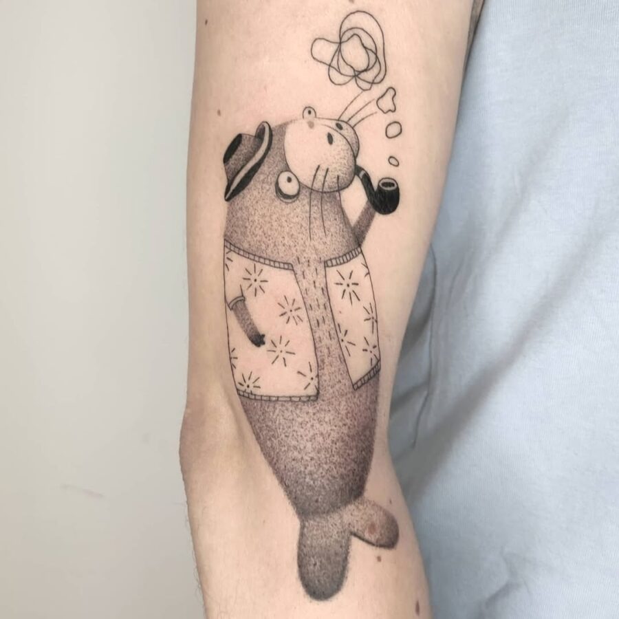 This tattoo showcases a cheerful manatee wearing a hat and blowing smoke rings.