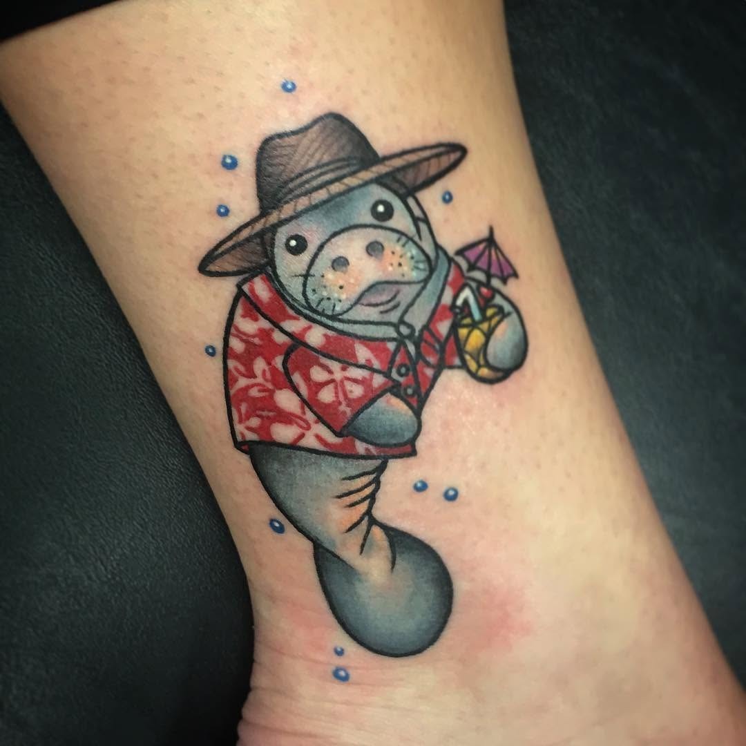 This tattoo features a charming manatee dressed in tropical gear.