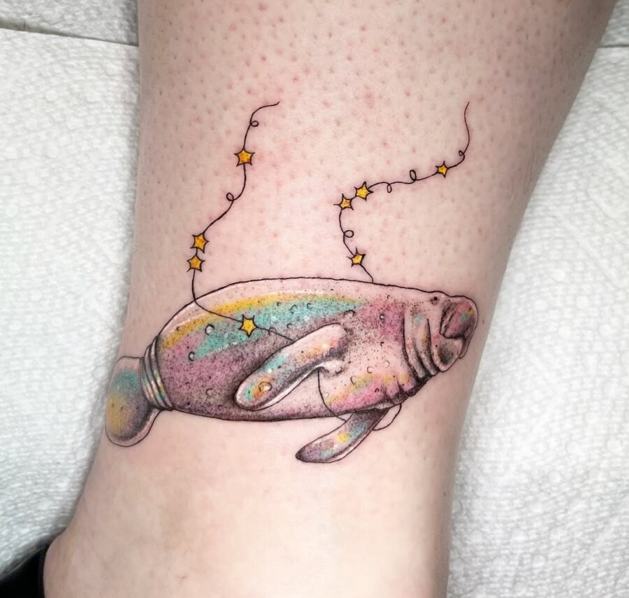 This colorful manatee tattoo showcases soft pastels combined with whimsical stars.