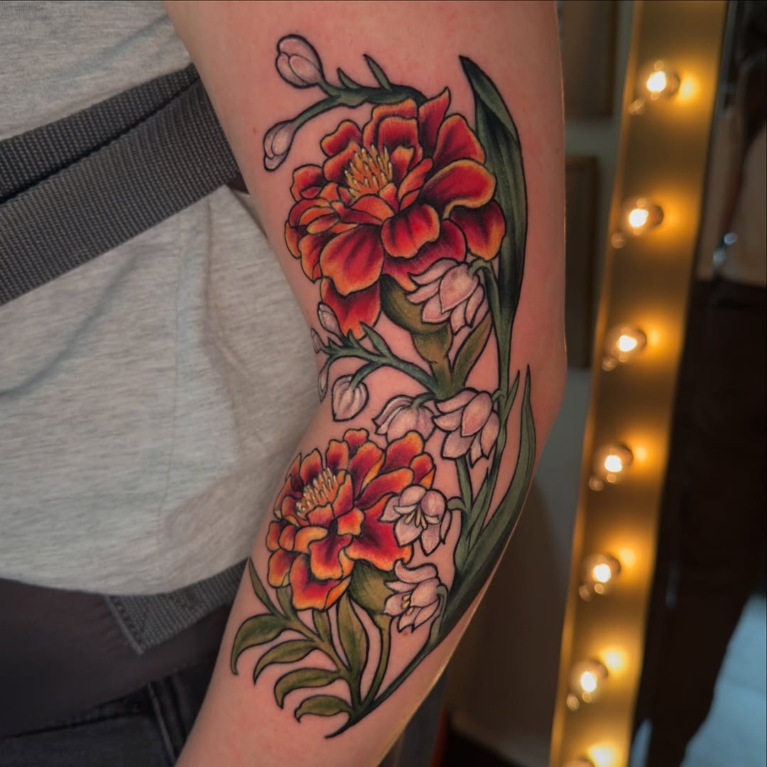 Bright marigold tattoo with floral accents Tattoo Design
