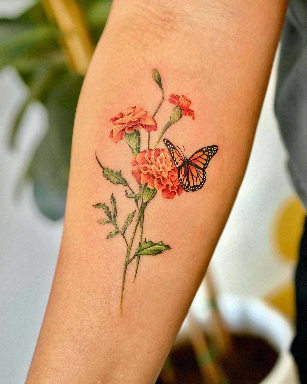 Colorful marigold tattoo featuring a butterfly Tattoo Design