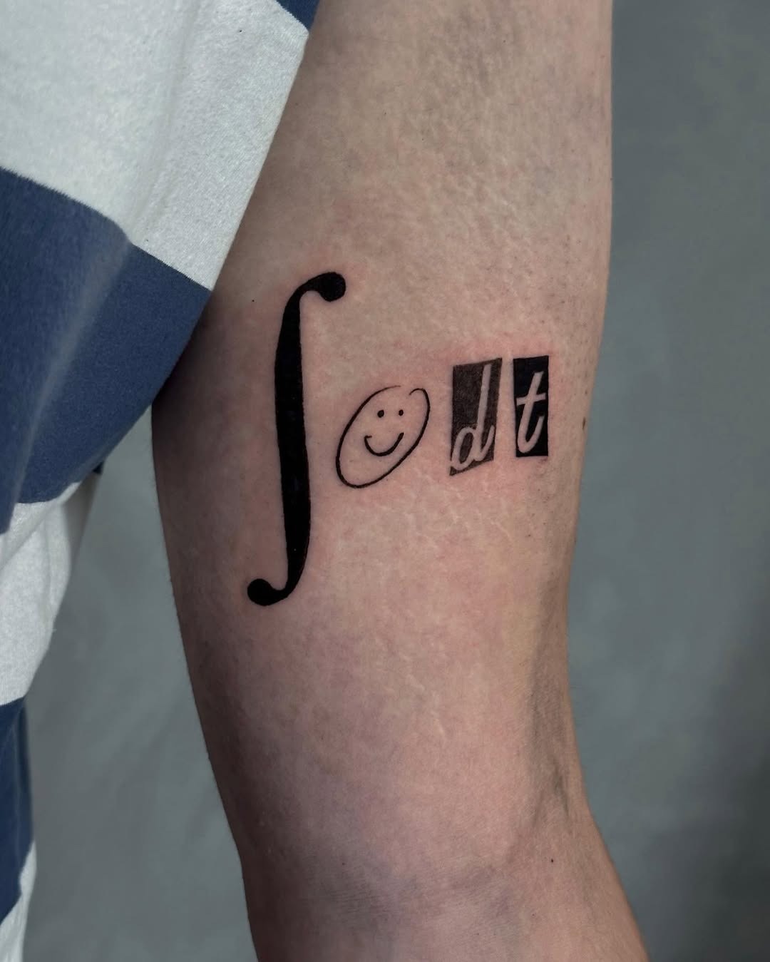 Integral symbol with a playful smiley face Tattoo Design