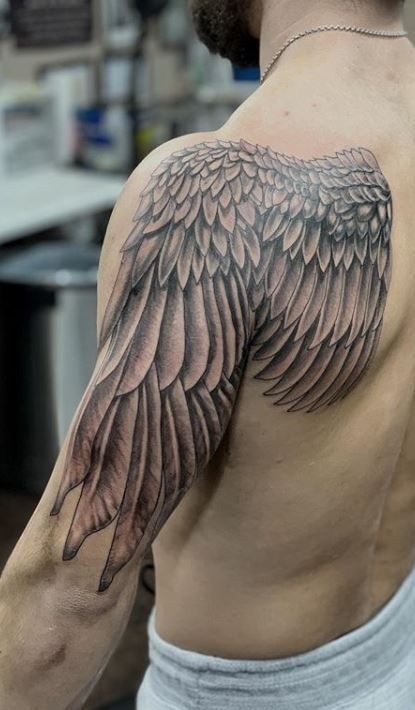 This wing tattoo makes excellent use of anatomical flow, spreading from the shoulder down the back of the arm in fluid, natural motion.