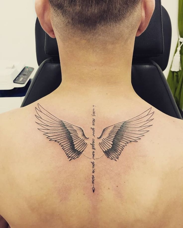 A poetic neck to back vertical tattoo featuring soft-drawn wings flanking a line of script and a downward arrow.