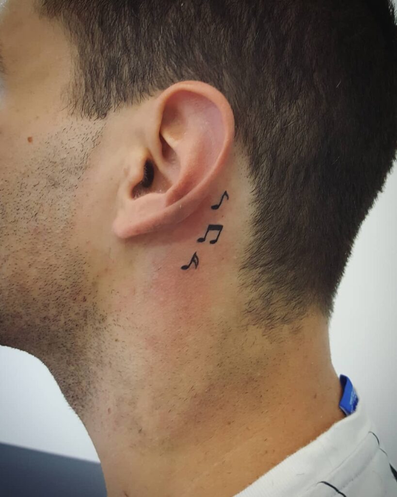 Flowing Musical Notes Behind the Ear Tattoo Design