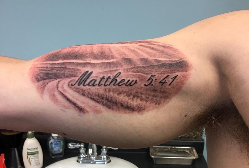 Isaiah 54:17 Bicep Tattoo with Clouds and Bold Lettering Tattoo Design