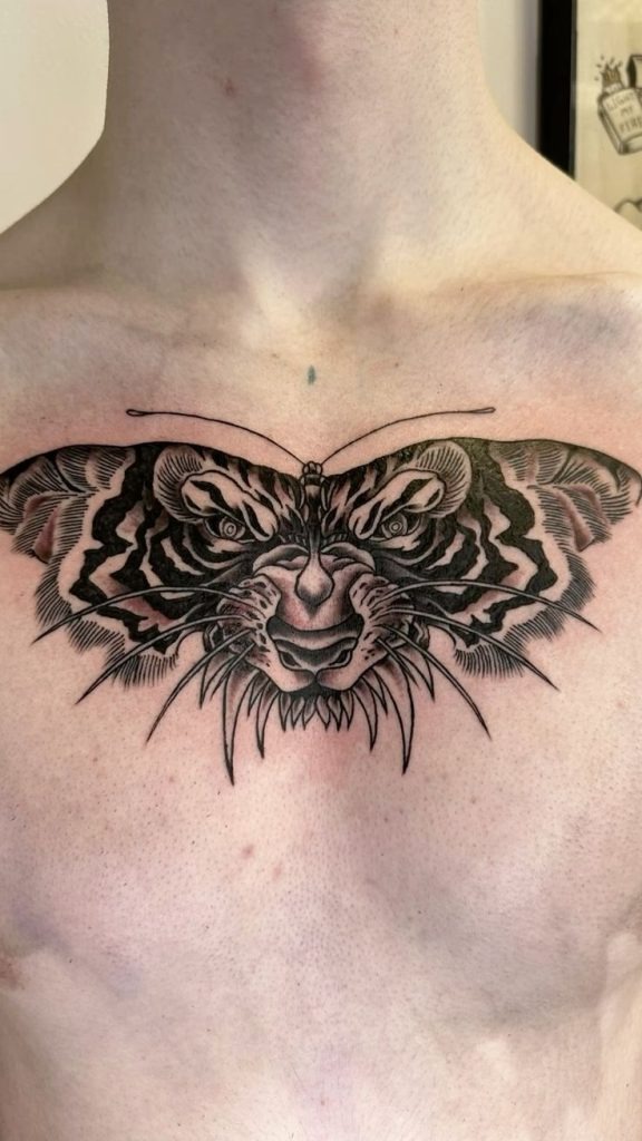Combining the features of a tiger and a moth, this chest tattoo is fierce, bold, and beautifully symmetrical.