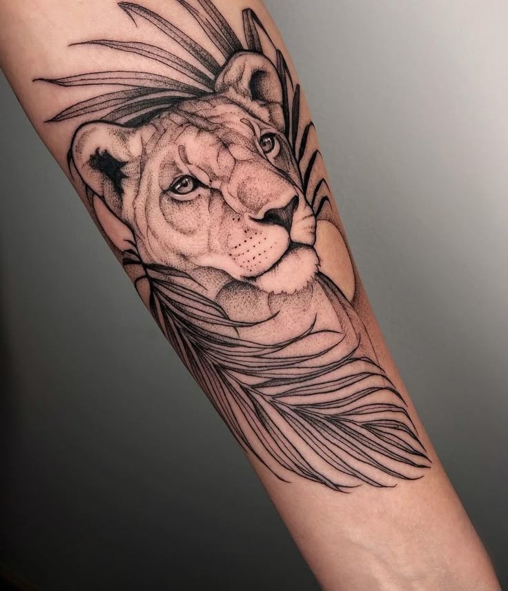 There's a quiet power in this tattoo, a lioness peering through abstract leaves, crafted in fine line realism with soft shading.