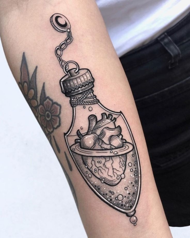 Inside a potion-like bottle floats an anatomical heart encircled by Saturn-like rings.