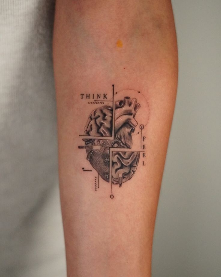 This tattoo splits the human heart in two, half brain, half heart, surrounded by geometric lines and subtle dotwork.