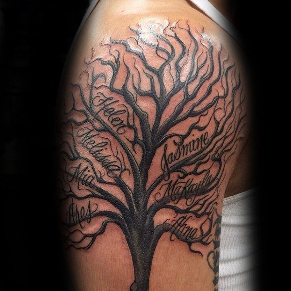 This shoulder tattoo features a sprawling tree, with names like Helen, Jasmine, and Mia written along the curved branches.