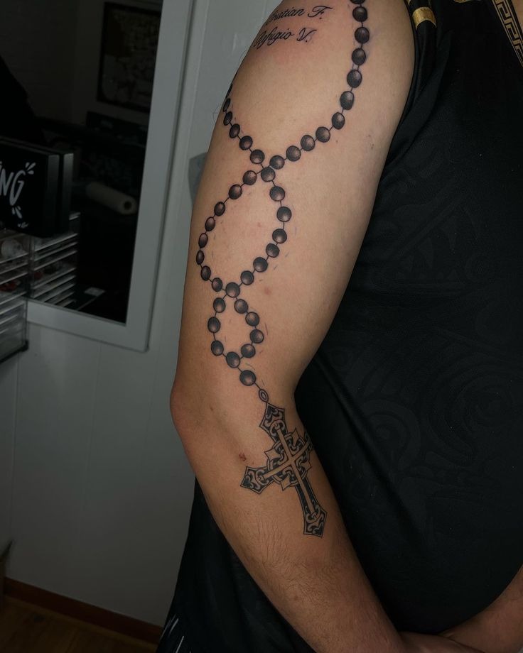 Bold Upper Arm Rosary Tattoo Design