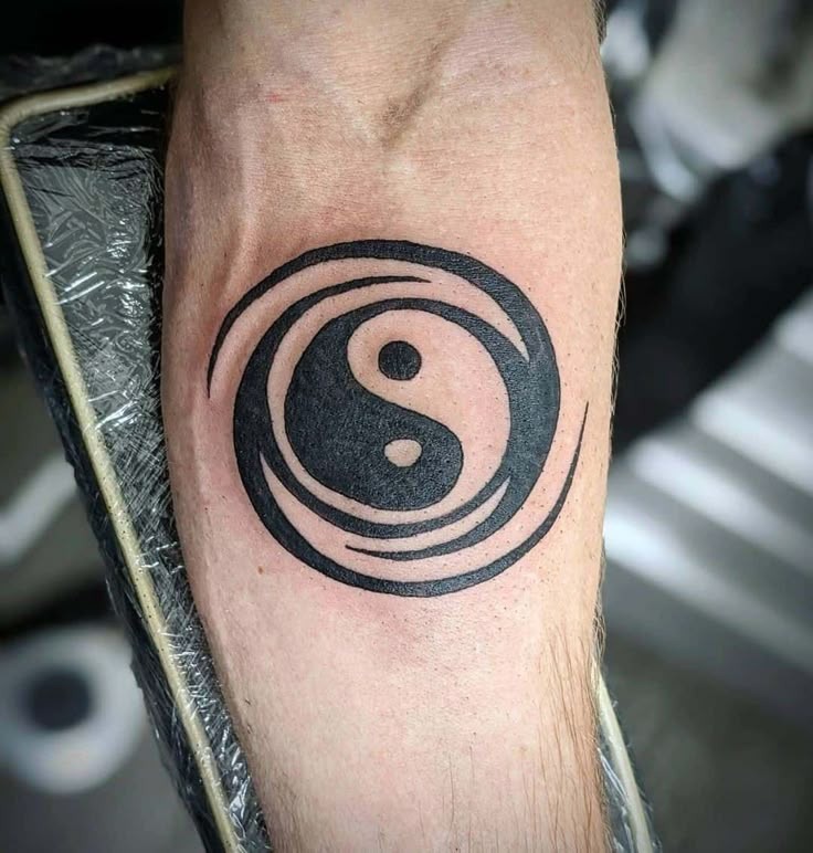 This high contrast tattoo depicts the classic Yin Yang symbol encircled by intense swirling lines that create a wave-like aesthetic.