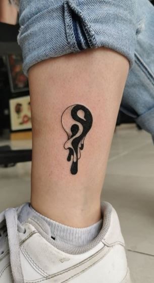 A playful yet rebellious Yin Yang tattoo shows the ink melting against the skin in a drop-like fashion.