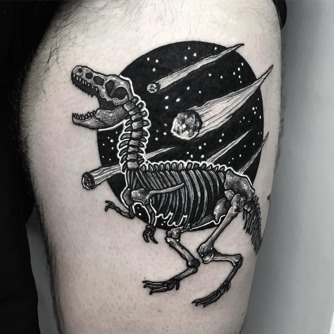 This striking tattoo features a dinosaur skeleton amidst a cosmic scene.