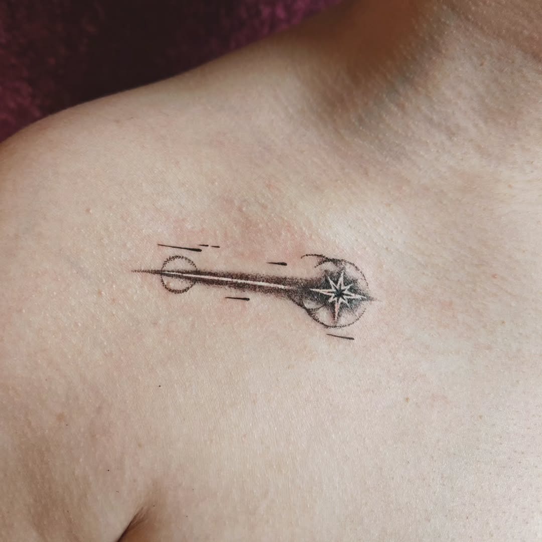 This tattoo showcases a sleek meteor design that seamlessly incorporates a compass element.