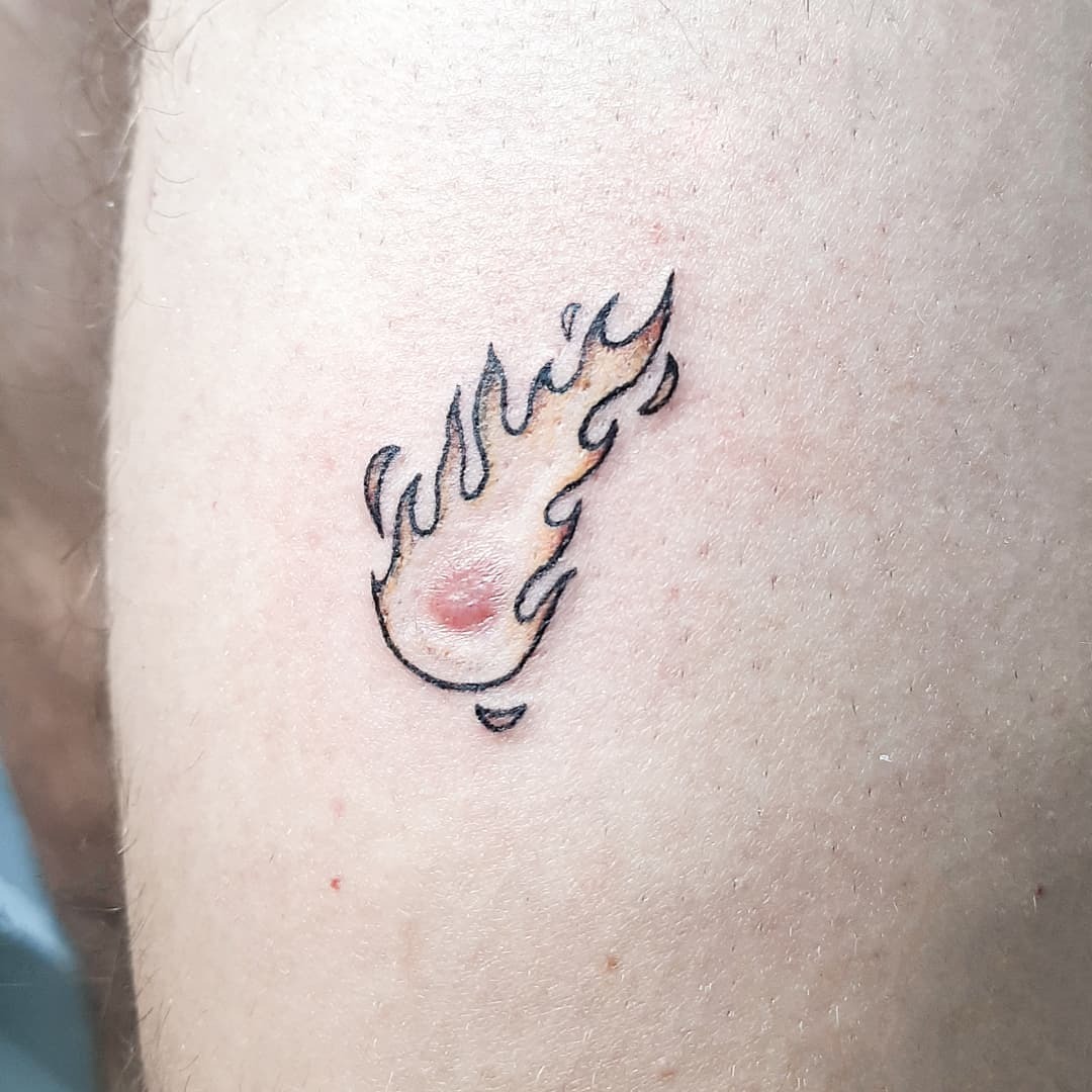 This unique meteor tattoo features flames licking around a small comet.
