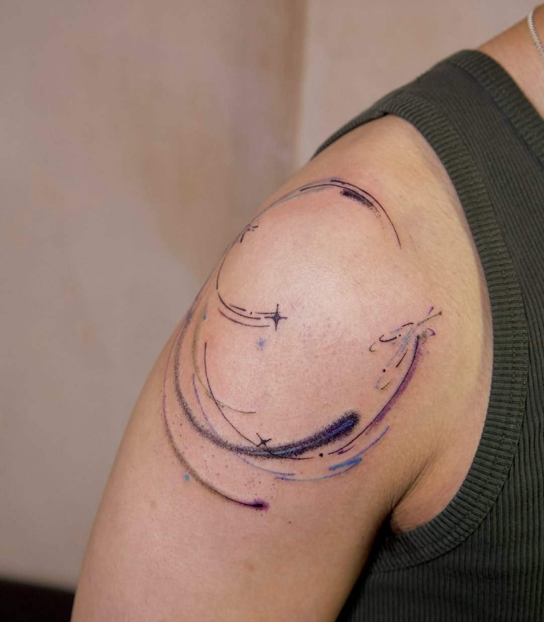 This meteor tattoo features elegant swirls and colorful splashes that evoke a sense of cosmic energy.