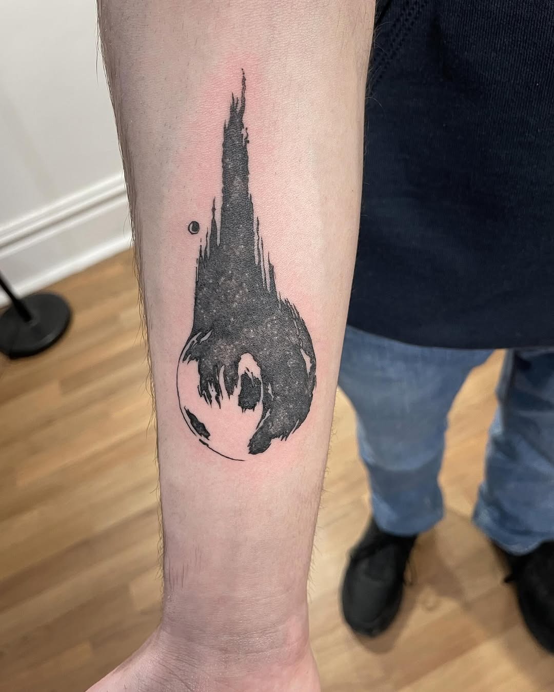 This tattoo features a striking meteor design, capturing the dynamic motion of a comet streaking across the skin.
