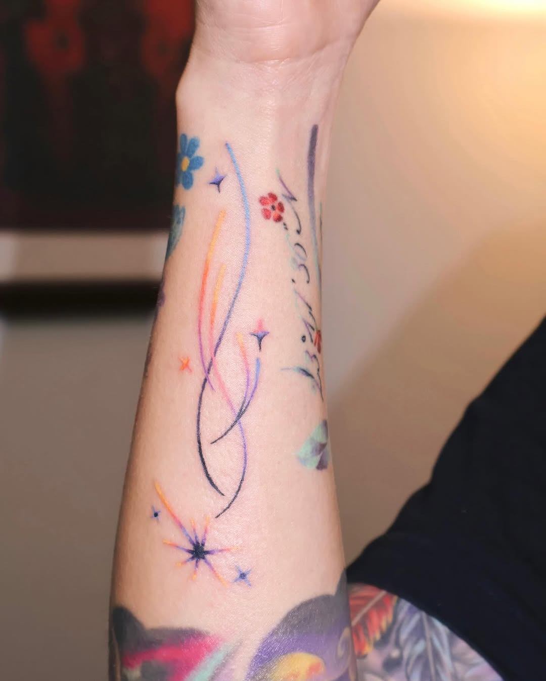 This tattoo features swirls and stars, creating a playful cosmic vibe.