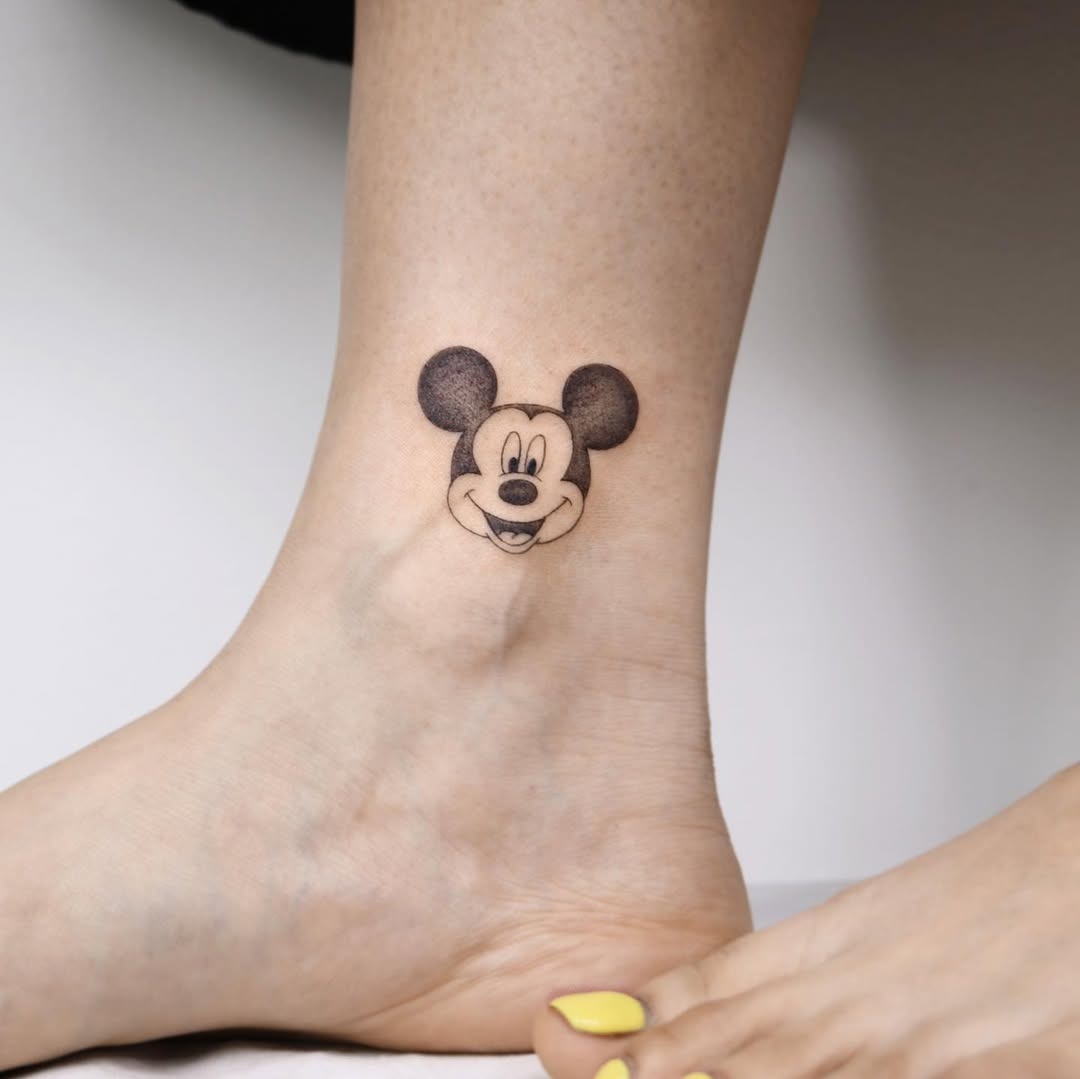 This playful tattoo features a classic Mickey Mouse design right on the ankle.