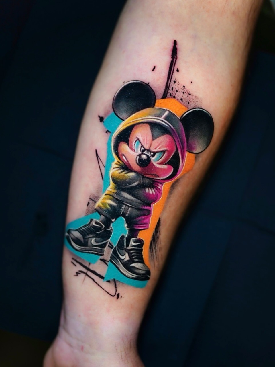 This tattoo showcases a Mickey Mouse enjoying a fun ride on a skateboard.