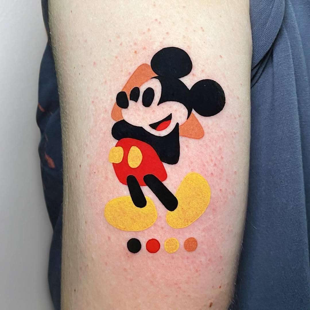 This lively tattoo features a colorful rendition of Mickey Mouse, showing his classic look with a modern twist.