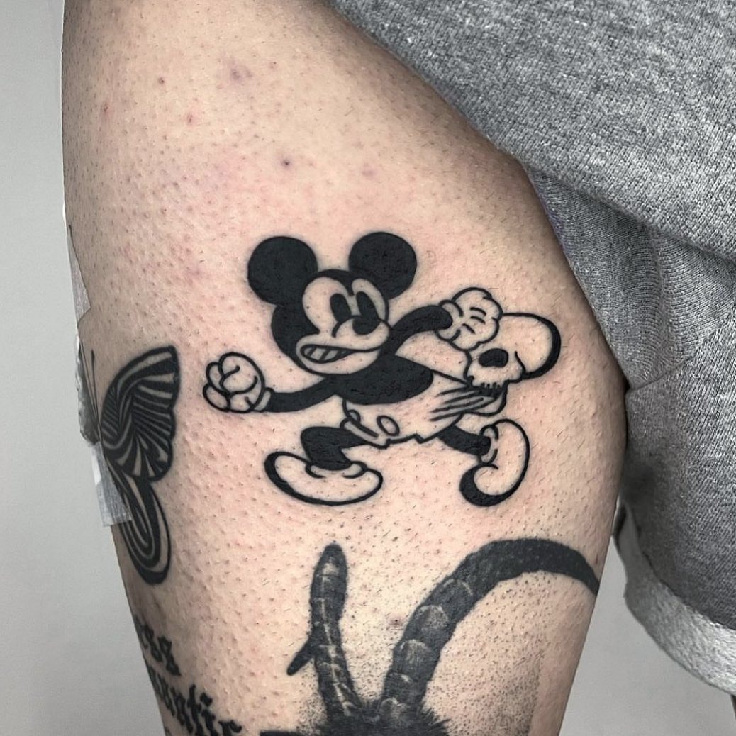 This tattoo showcases Mickey Mouse in a lively running pose, embodying energy and fun.