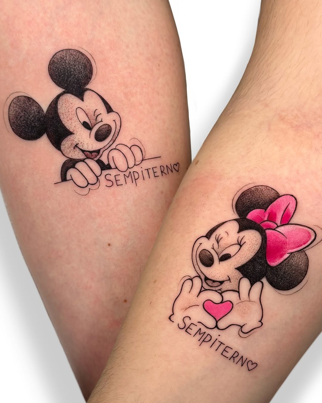 This image showcases a tattoo featuring Mickey and Minnie Mouse in a playful pose.