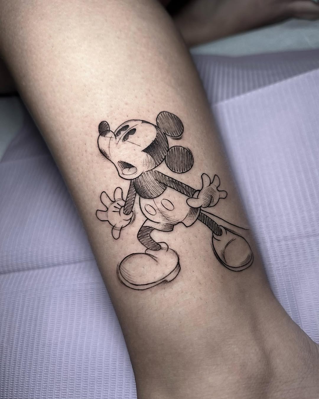 This tattoo showcases an expressive Mickey Mouse with exaggerated features, portraying a playful and animated vibe.
