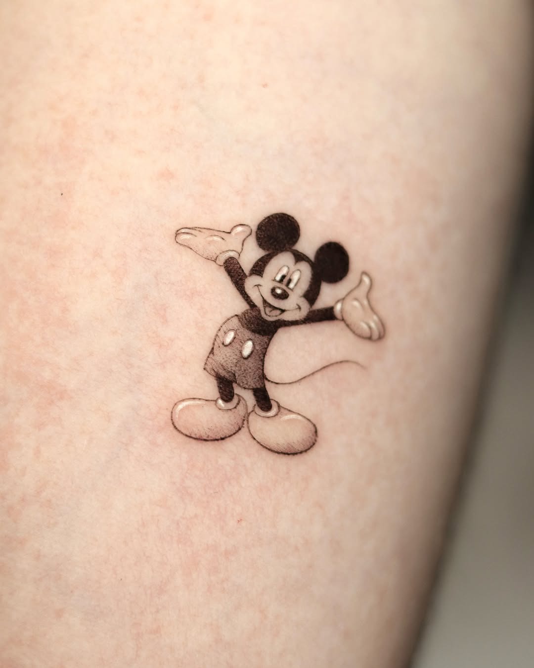 This adorable Mickey Mouse tattoo features the iconic character with his arms open wide.