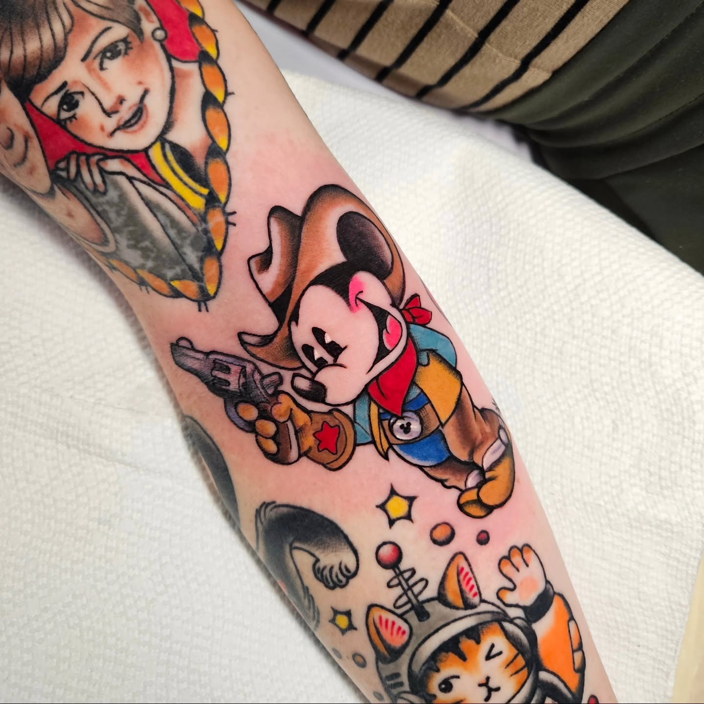 This playful tattoo features Mickey Mouse dressed as a cowboy, complete with a hat and gun.