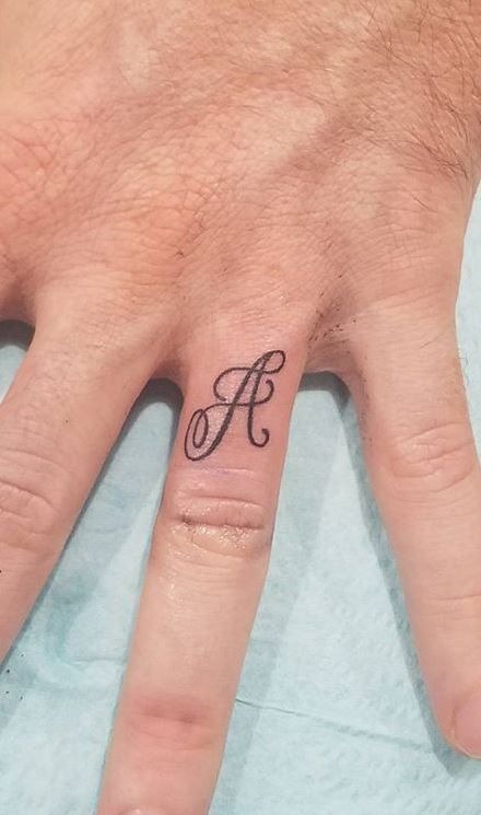 An A in a traditional cursive font adorns the finger in this tattoo, reflecting a timeless choice in both font and initials.