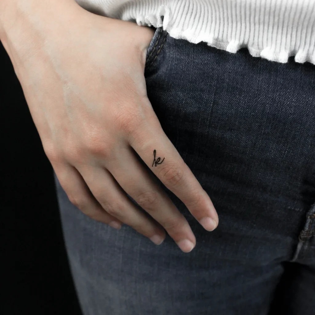 For a touch of contemporary chic, a wrist tattoo of the letter A showcases elegance with its fine cursive style.