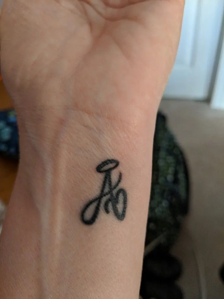 Lastly, an example of a letter A tattoo placed behind the ear, a location chosen for its intimacy and subtlety.