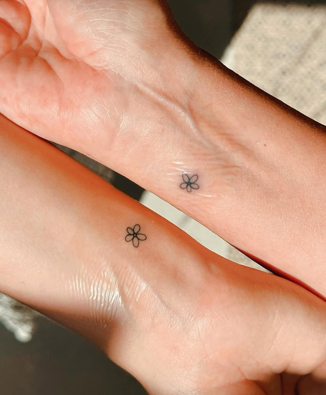 Charming minimalist flower tattoos on wrists Tattoo Design