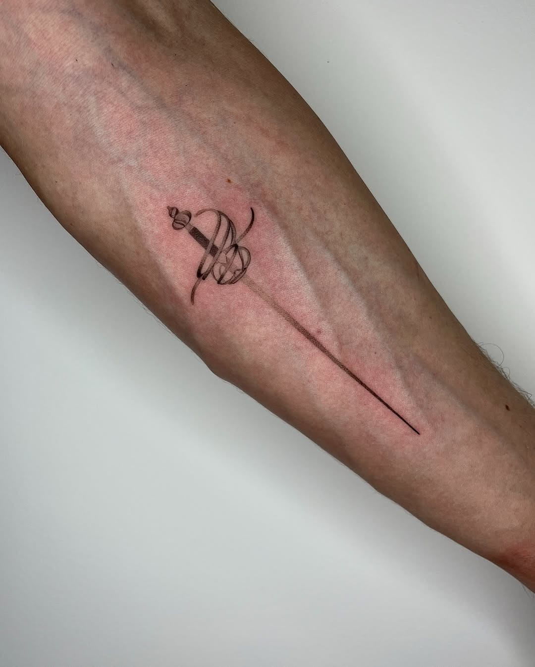 Elegant minimalist sword tattoo on forearm Tattoo Design