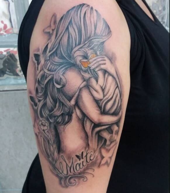 Capturing a mother gently holding her baby, this tattoo is rich in detail and emotion.